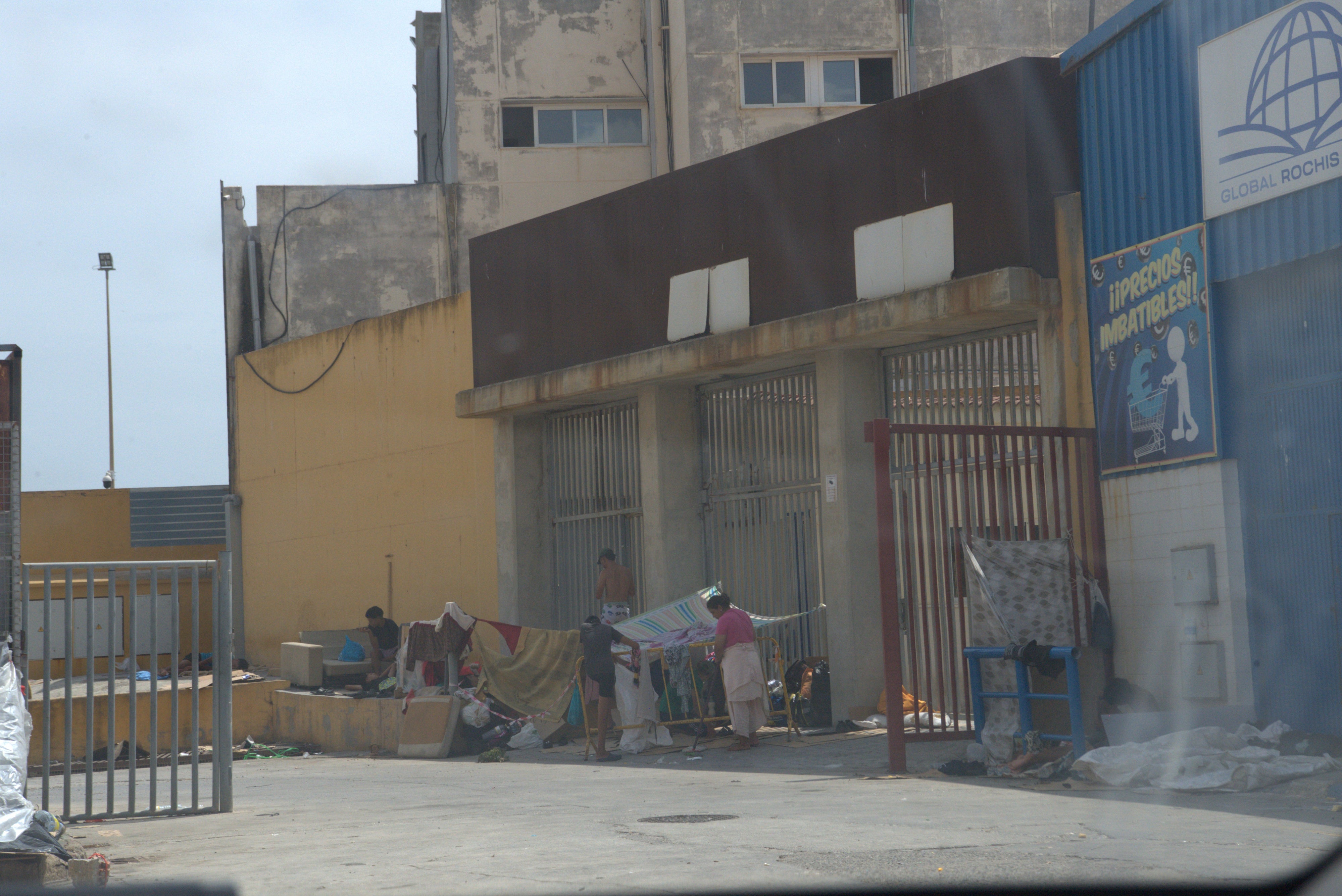 A woman tidies around her makeshift shelter in the warehouse district