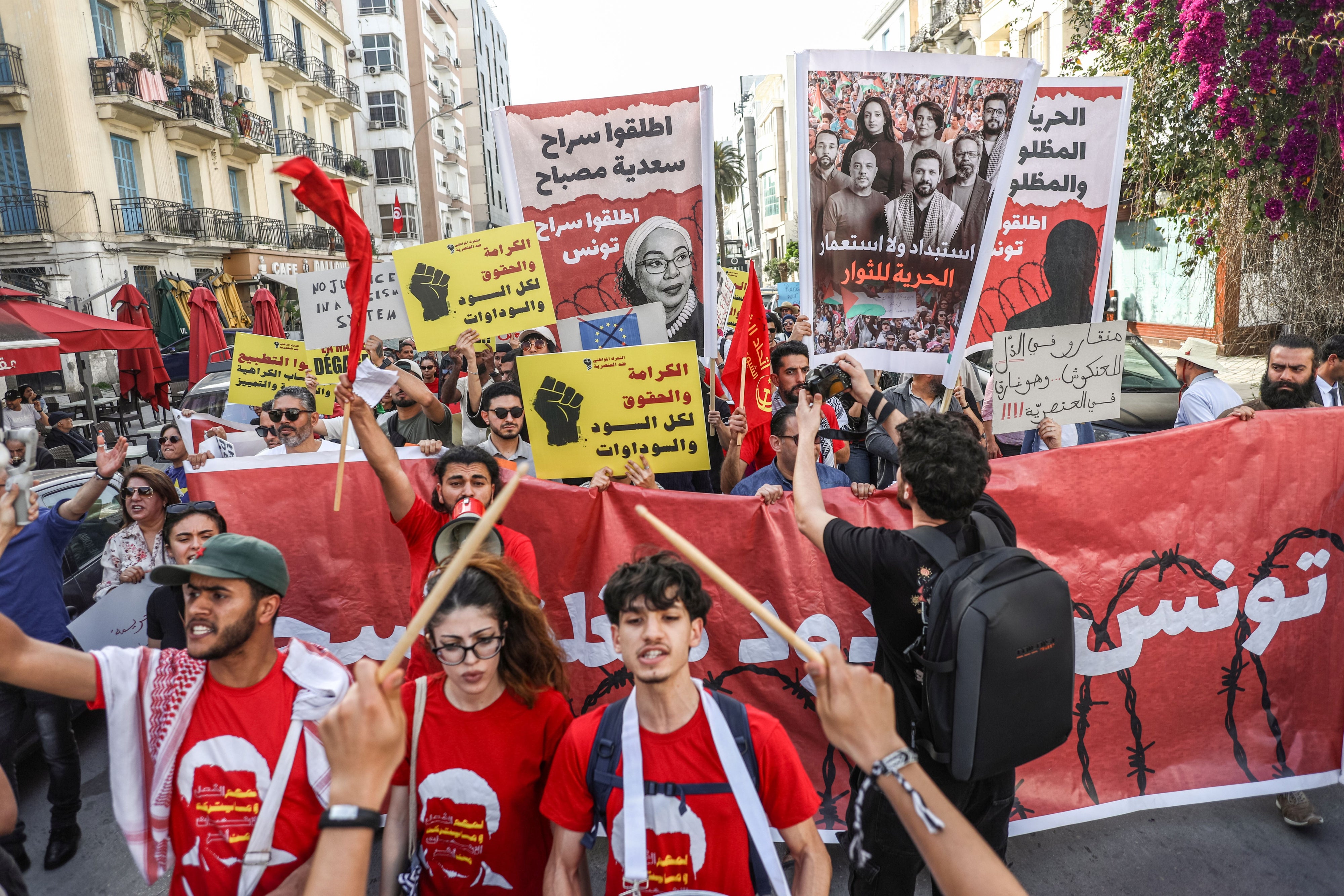 تونسيون يرفعون لافتات خلال مسيرة نظمتها "حملة ضد تجريم العمل المدني" احتجاجا على العنصرية في تونس العاصمة، في 11 أبريل/نيسان 2026. وتأتي هذه المظاهرة، التي تضم منظمات حقوقية ومجموعات من المجتمع المدني ونشطاء، لتعبر عن المخاوف بشأن ما يصفه المشاركون بأنه تصاعد في الخطاب العنصري، فضلا عن الجهود الرامية إلى تجريم التضامن والأنشطة المدنية والسياسية والنقابية. كما تسلط هذه الفعالية الضوء على المخاوف بشأن استهداف النشطاء والمدافعين عن الحقوق.