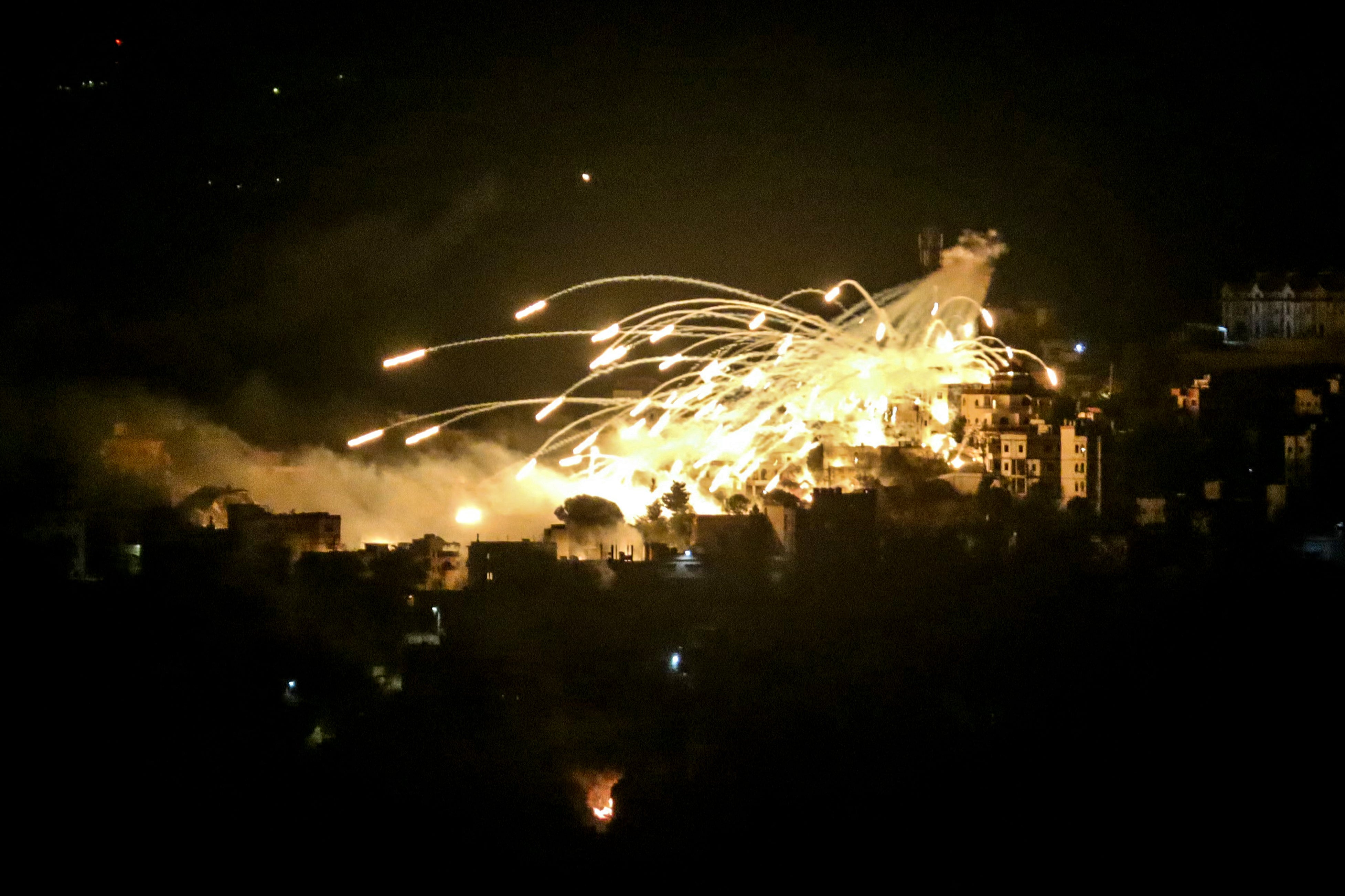 A white phosphorus munition airbursts over buildings in the town of Khiam in southern Lebanon during an Israeli bombardment on October 31, 2024.