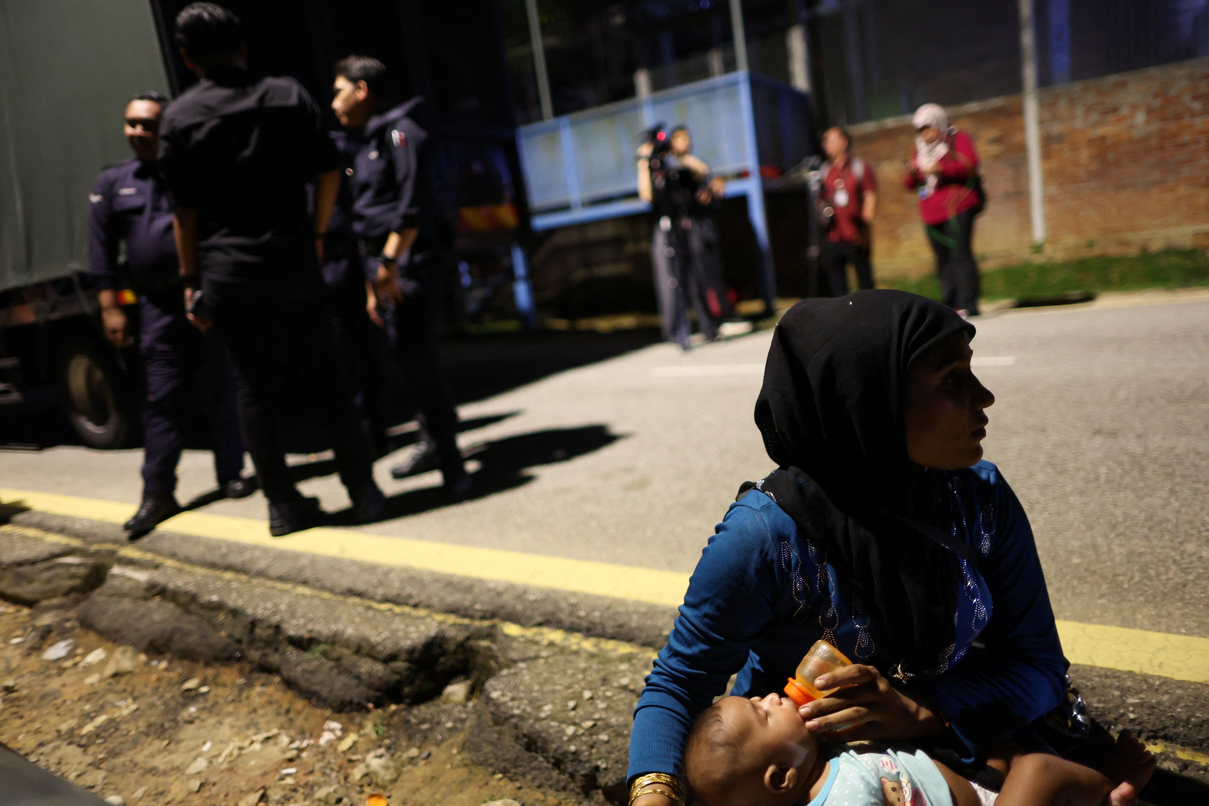 Une réfugiée rohingya donne à manger à un enfant devant les locaux de l'Agence des Nations Unies pour les réfugiés à Kuala Lumpur, en Malaisie, le 27 juillet 2026.