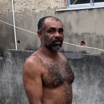 photo of a shirtless man walking down a street