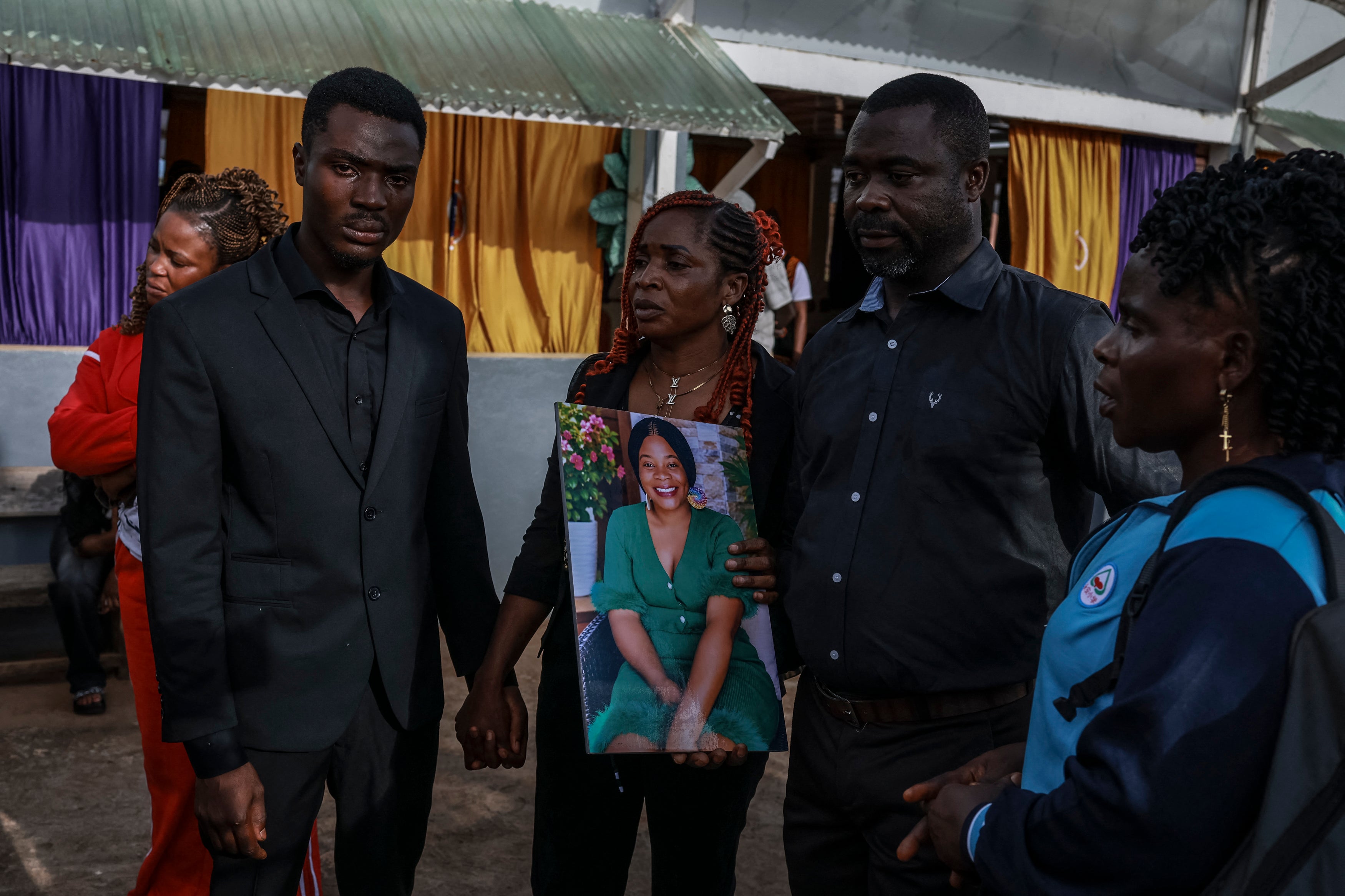 Family members hold a portrait of Geraldine Buweh Atsie, a victim of femicide, at the Jamot Hospital in Yaounde on September 18, 2026.