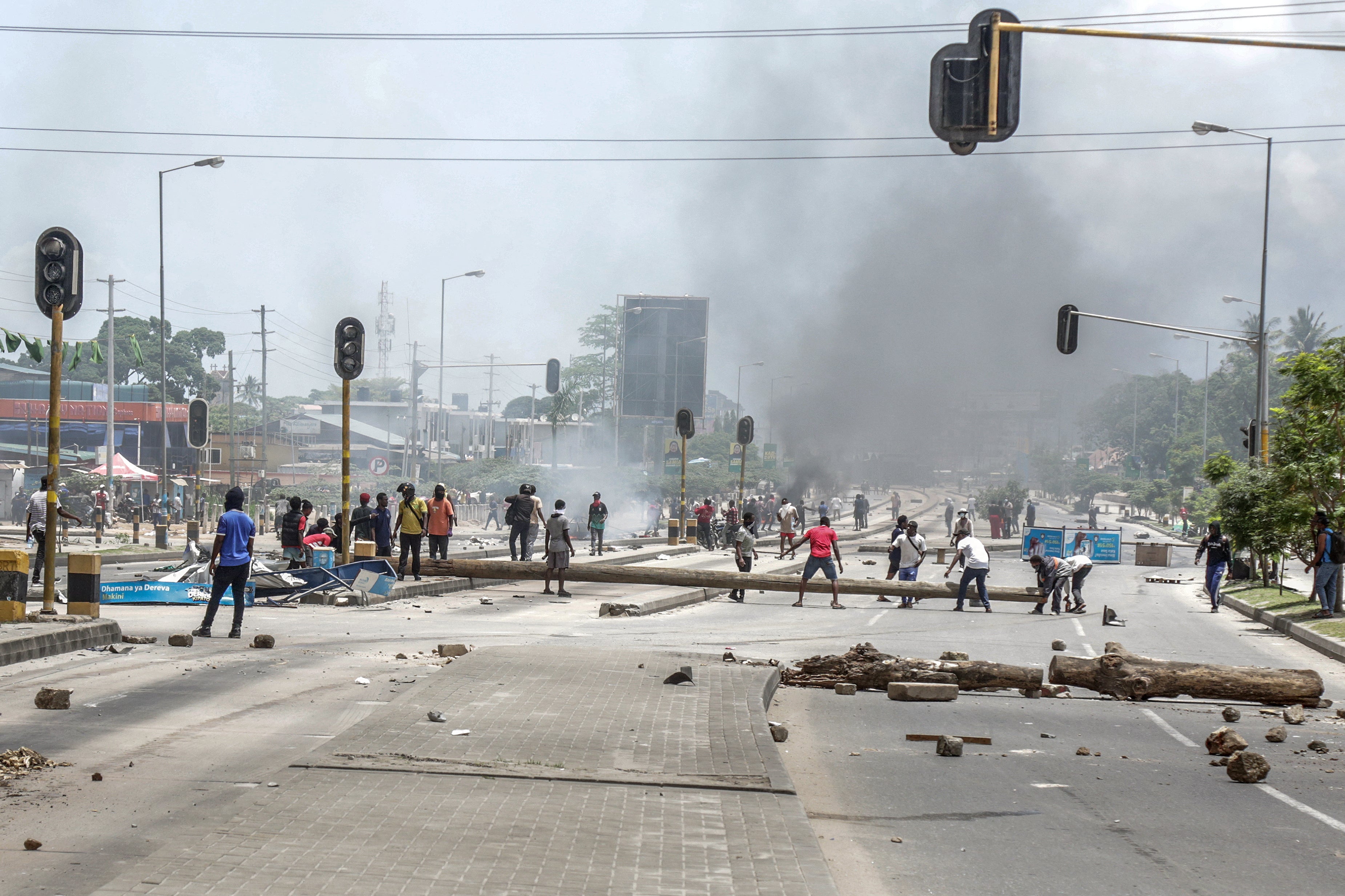Protesters use different materials to build barricades and block a road as clashes erupt in Dar es Salaam during Tanzania's presidential elections on October 29, 2025.