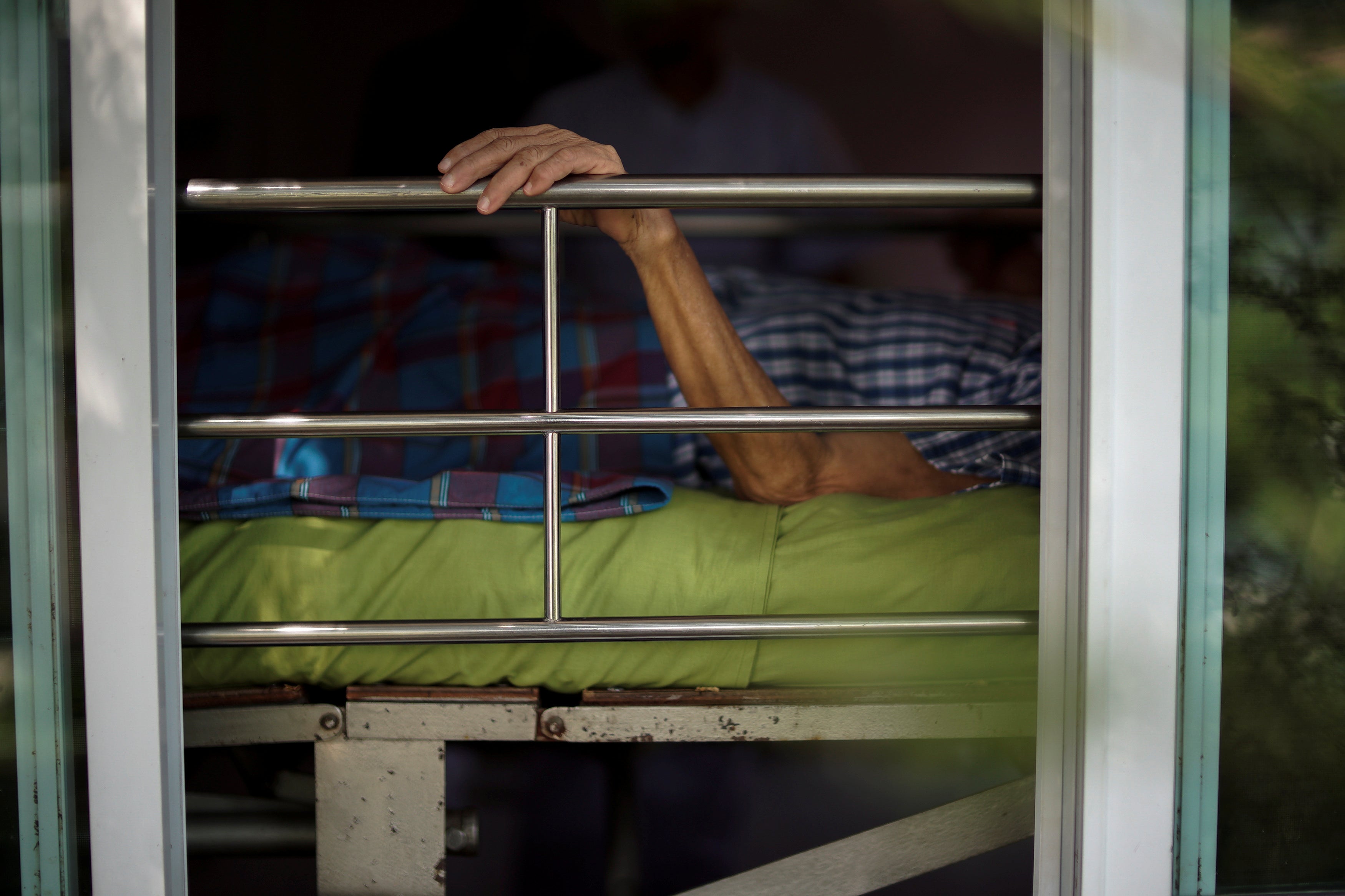 A person lies in bed at a nursing home in Ayutthaya, Thailand, April 9, 2016.