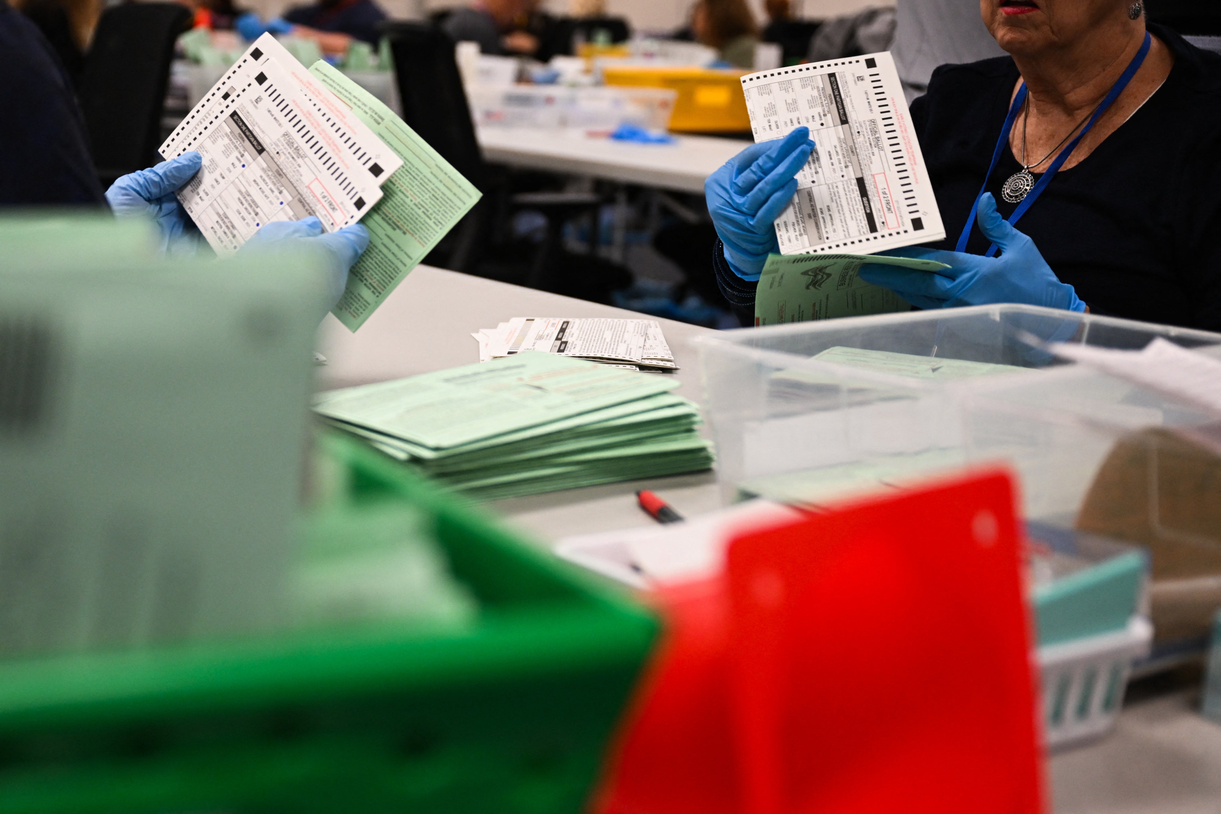 US election workers open and inspect mail-in ballot envelopes during processing inside the Maricopa County Tabulation and Election Center (MCTEC) on Election Day, November 5, 2024, in Phoenix, Arizona.
