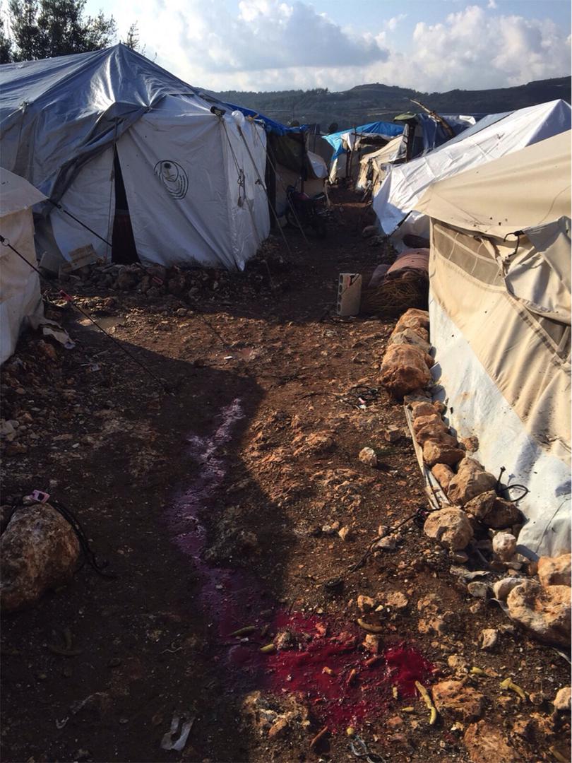 دم على الأرض في مخيم للنازحين بالقرب من قرية اليونسية في إدلب بعد هجوم بذخائر عنقودية على المخيم في 9 نوفمبر/تشرين الثاني 2015.