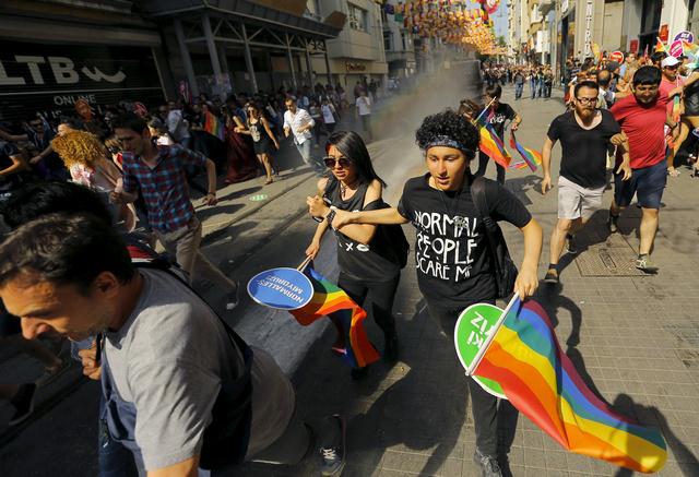 LGBT rights activists run as riot police use a water cannon to disperse them before a Gay Pride Parade in Istanbul, Turkey, on June 28, 2015.