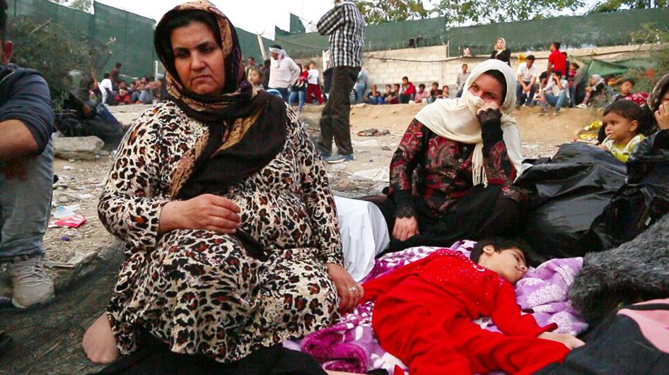 Screenshot taken from video footage of an Afghan woman with her 15-year-old daughter who has multiple disabilities on the ground outside the Moria registration camp on the Greek island of Lesbos. October 5, 2015. © 2015 Human Rights Watch