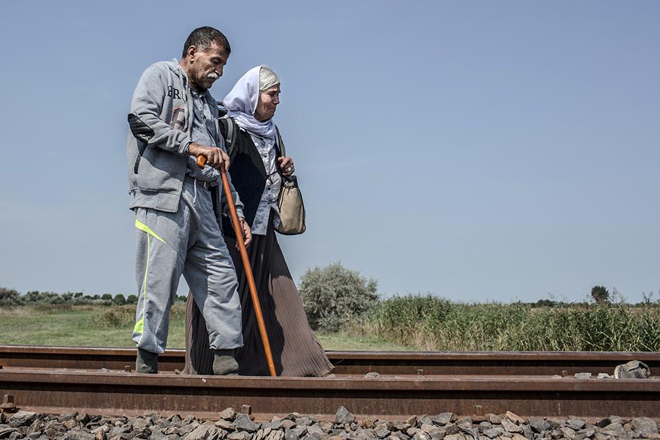 Hassan and his wife Sheri, both Iraqi Kurds, walk along train tracks in Röszke, Hungary after crossing the border with Serbia. September 3, 2015.