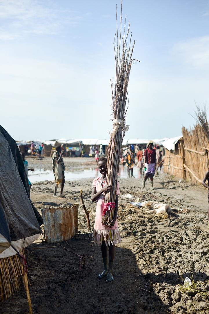 A girl carrying firewood in the UNMISS camp near Bentiu in June, 2015. 