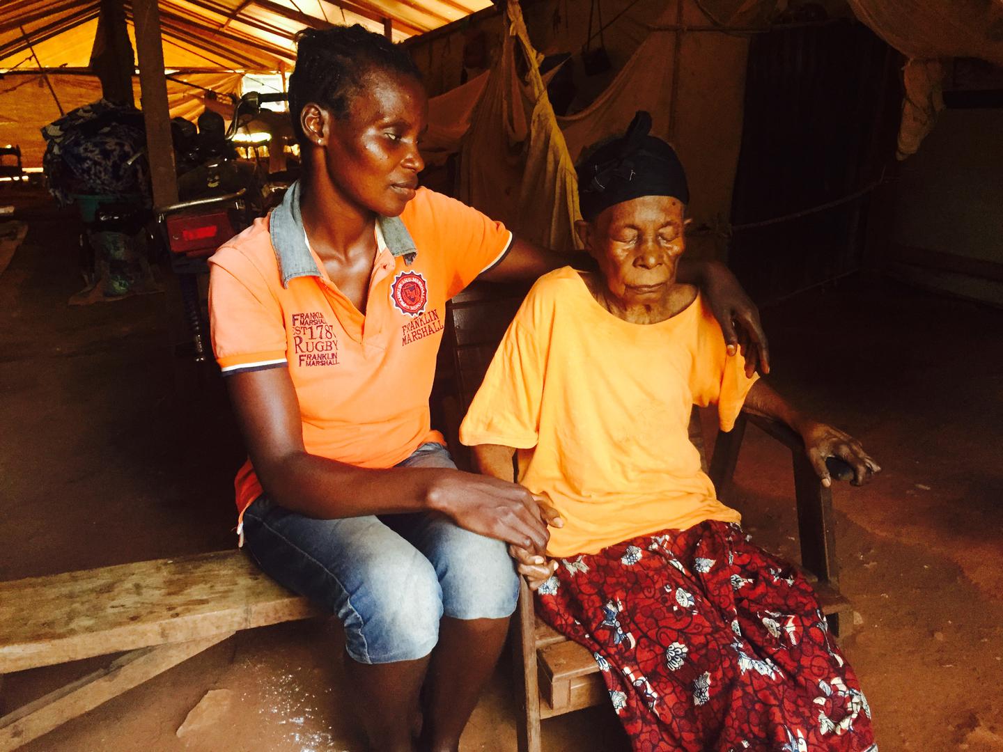Marie Doloko, une aveugle de 95 ans, avec un membre de sa famille sur le site de personnes déplacées de Bimbo. Le 29 octobre, deux combattants musulmans ont tenté de la brûler vive chez elle. Elle a été sauvée de l’incendie par sa petite-fille. 