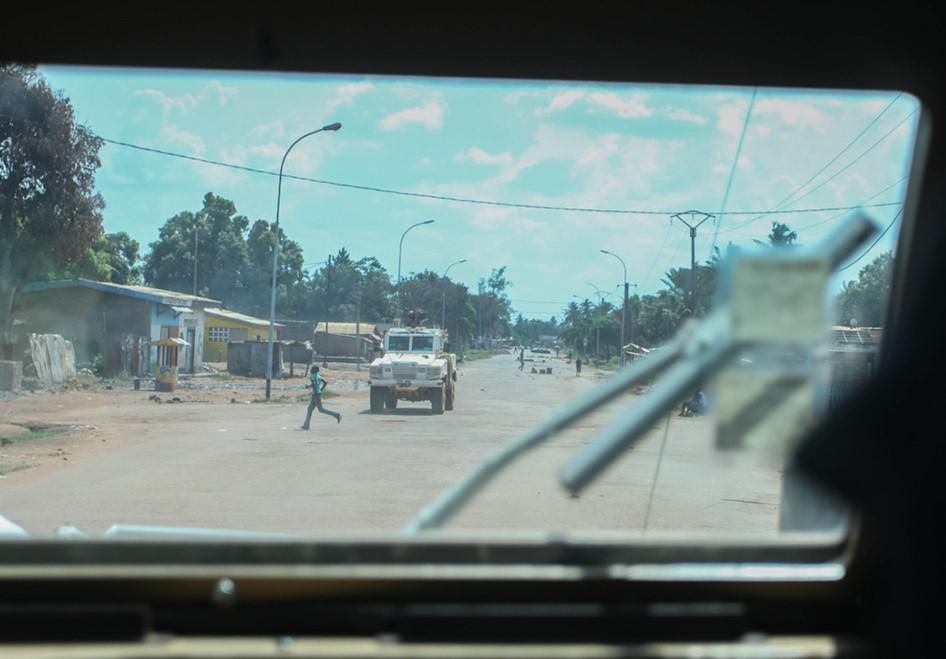 Un garçon traverse la route en courant devant un véhicule de police de la MINUSCA en patrouille dans le quartier de Bazanga à Bangui, le 5 octobre 2015.