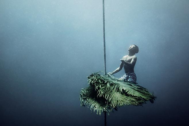 一名渔人沿袭传统技巧，用绳索捆著棕梠叶缒至海面下70-80公尺，引诱深海礁石中的鱼类。