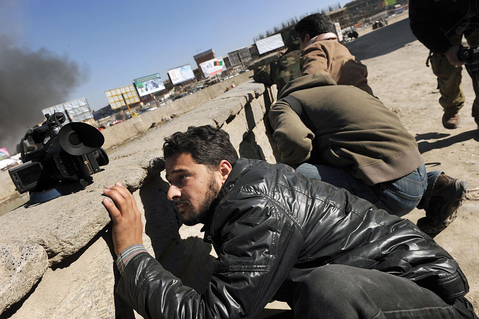 一群阿富汗新闻记者正在寻找掩护。2010年1月18日，塔利班好战分子在阿富汗首都喀布尔发动一连串有计划攻击，造成至少10人死亡，32人受伤。
