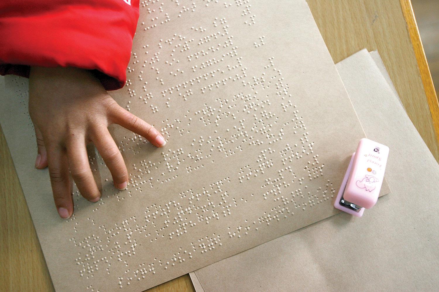 A blind girl reads Braille text in her class at the Shanghai School for the Blind in Shanghai.