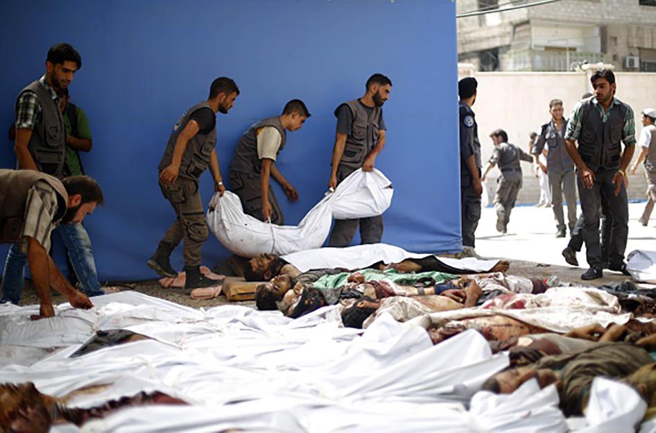 Grupo de emergência se encontra ao redor de corpos envoltos em panos após ataques aéreos por parte das forças do governo sírio a um mercado na área controlada por rebeldes em Douma, a leste da capital Damasco, na Síria. 16 de agosto de 2015.