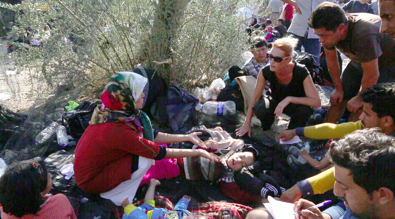 Screenshot taken from video footage of a Human Rights Watch researcher talking with an Afghan woman with her 9-year-old son who has epilepsy, while they await registration at the Moria camp on the Greek island of Lesbos. October 5, 2015.