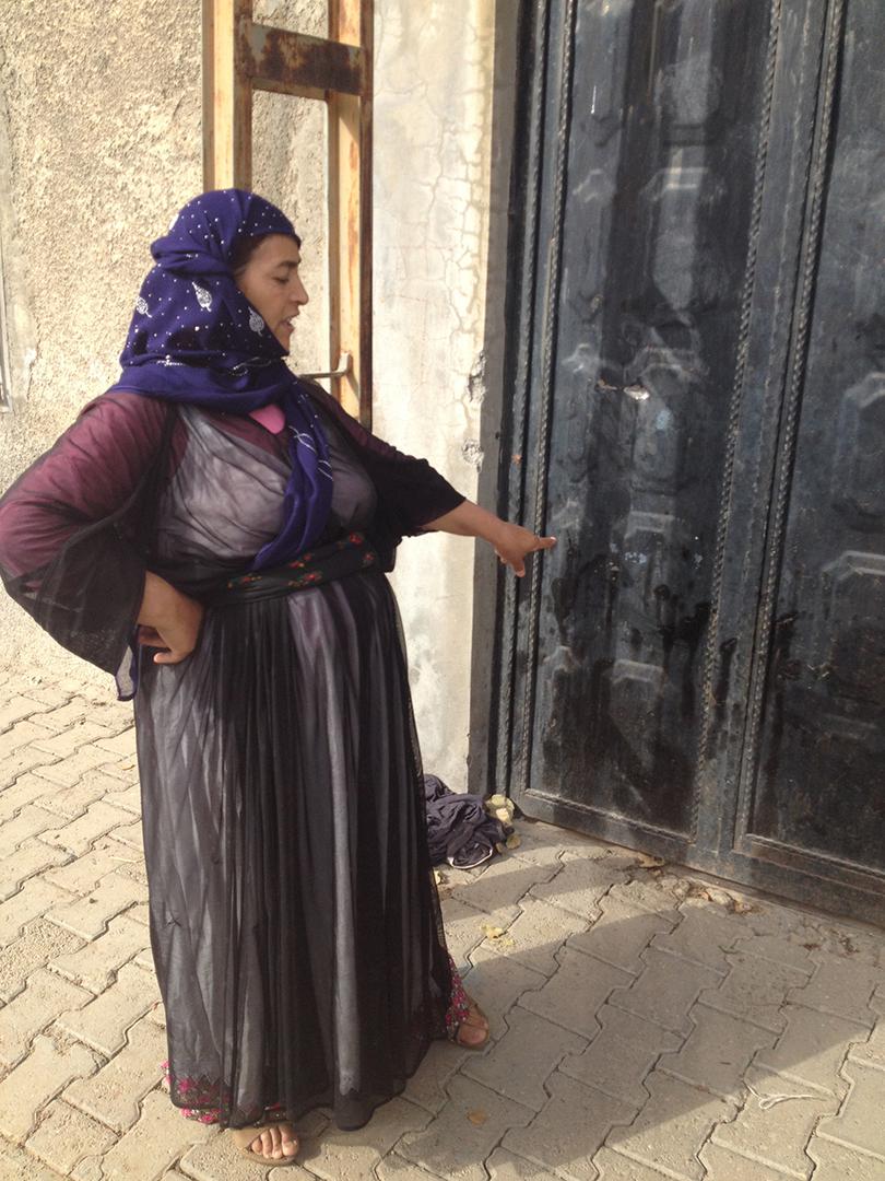 Şirin Sarak shows the place where her husband Suphi Sarak was shot dead on September 8, 2015 in Botaş Street, Cizre. Traces of Suphi Sarak’s blood remain on the gate of the home of their neighbour Bahattin Sevinik. Sevinik had been fatally shot through th