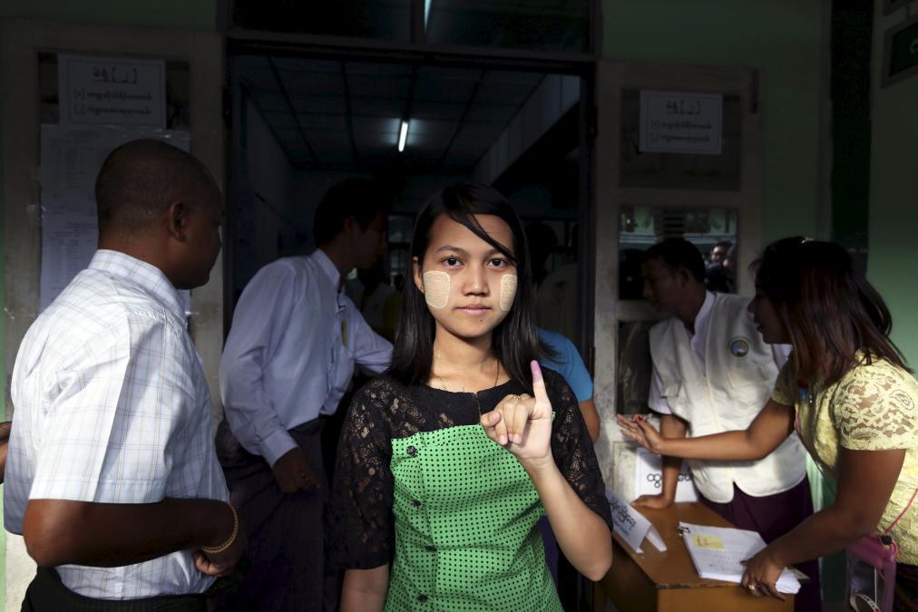 A woman shows her inked finger after casting her ballot during general elections in Rangoon on November 8.
