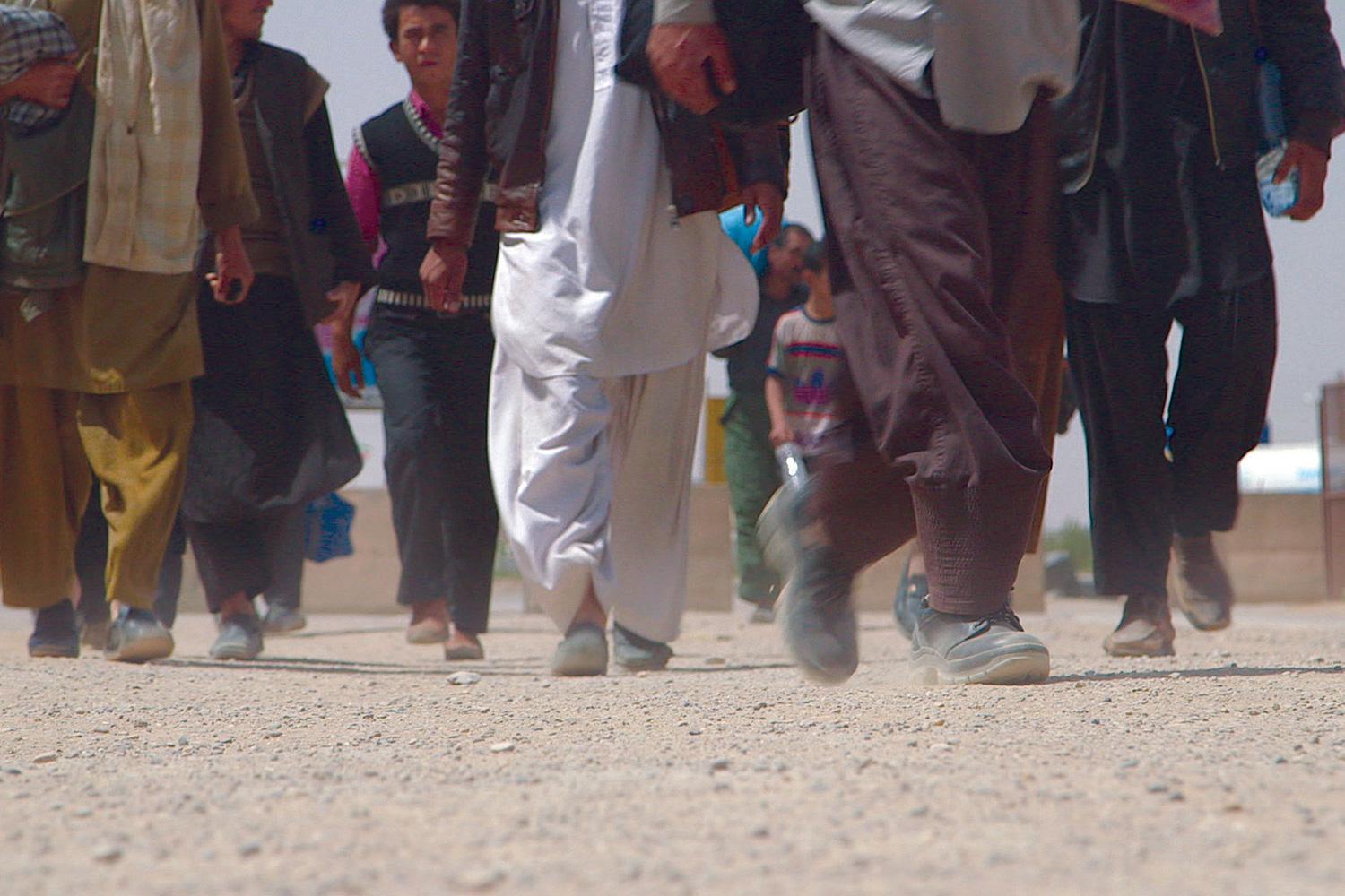 Afghans cross the border from Iran back into Afghanistan near Islam Qala, Afghanistan, in April 2013.