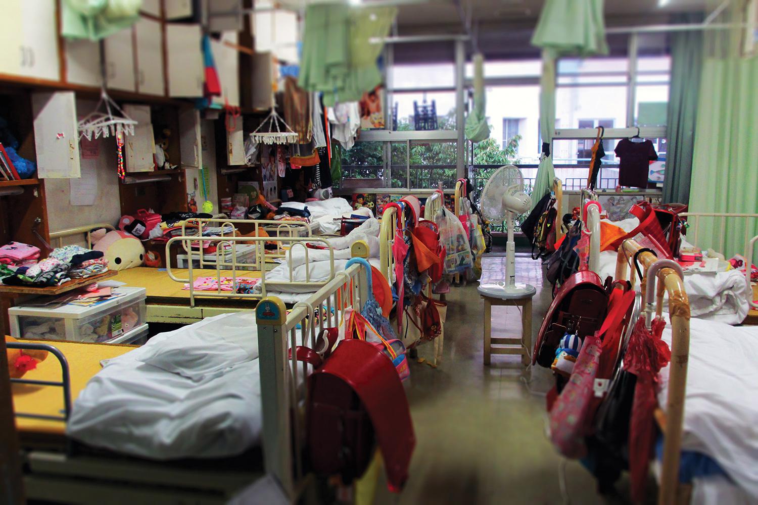 Beds in sleeping quarters for elementary school girls at a child care institution in Iwate prefecture. Eight girls share a room, and the space on their own bed is the only place children are allowed some privacy. 