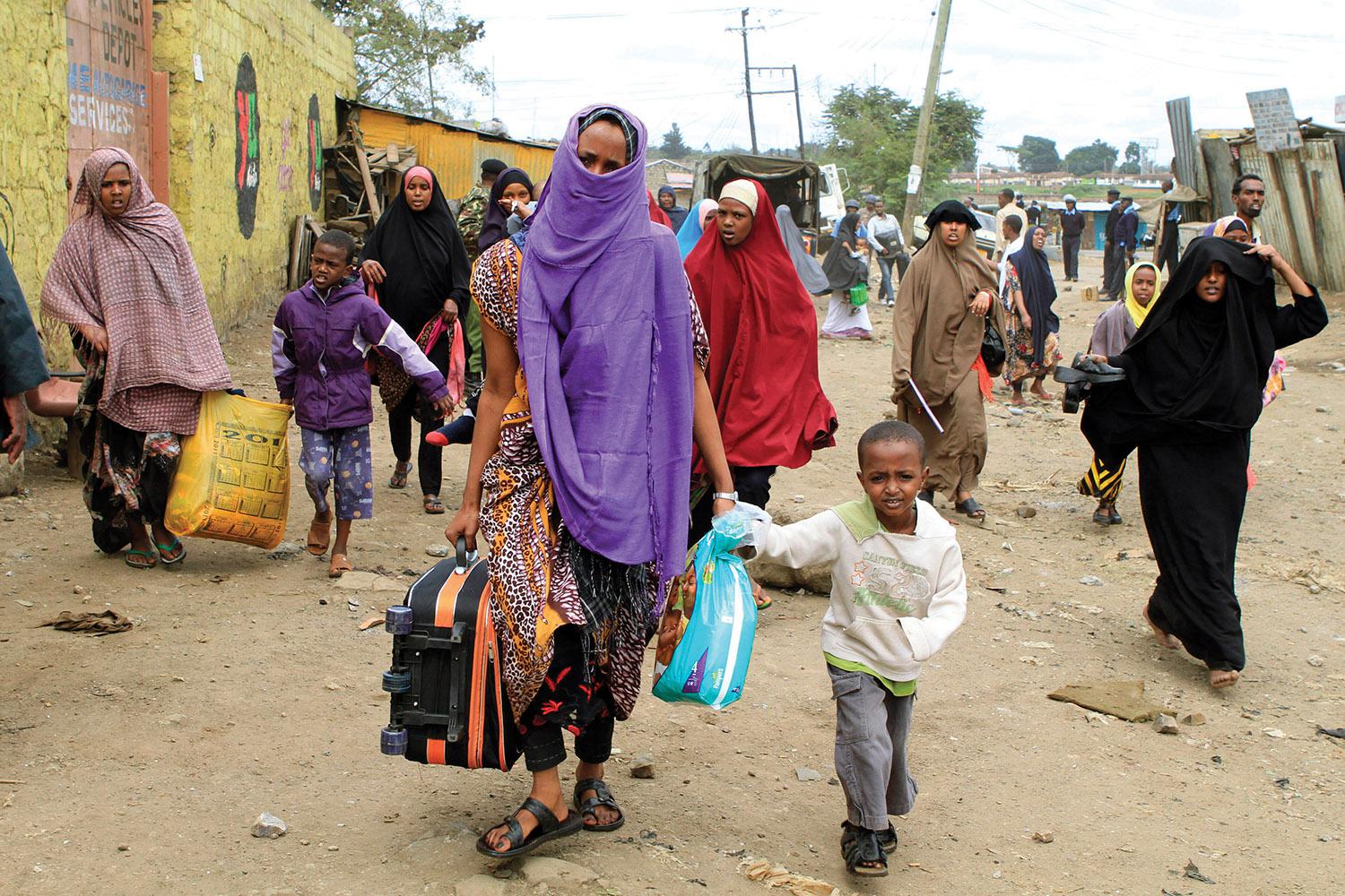 Somali women and children fleeing their homes in Nairobi’s predominantly Somali suburb of Eastleigh on November 20, 2012, two days after an attack on a bus by unknown perpetrators caused Kenyan gangs to riot and attack Somali refugees and Somali Kenyans. 