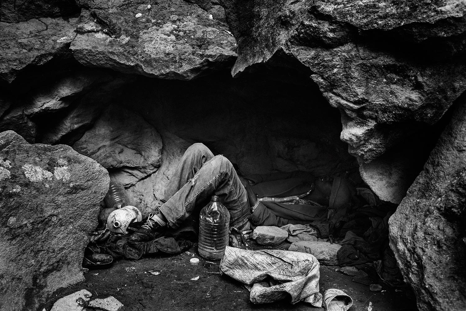 Nador, Morocco, November 2012 – A migrant from Mali lying down in a cave used as shelter. In the forests and mountains that surrounded Nador, groups of Sub-Saharan African migrants survive and wait for the right moment to attempt to cross the border.
