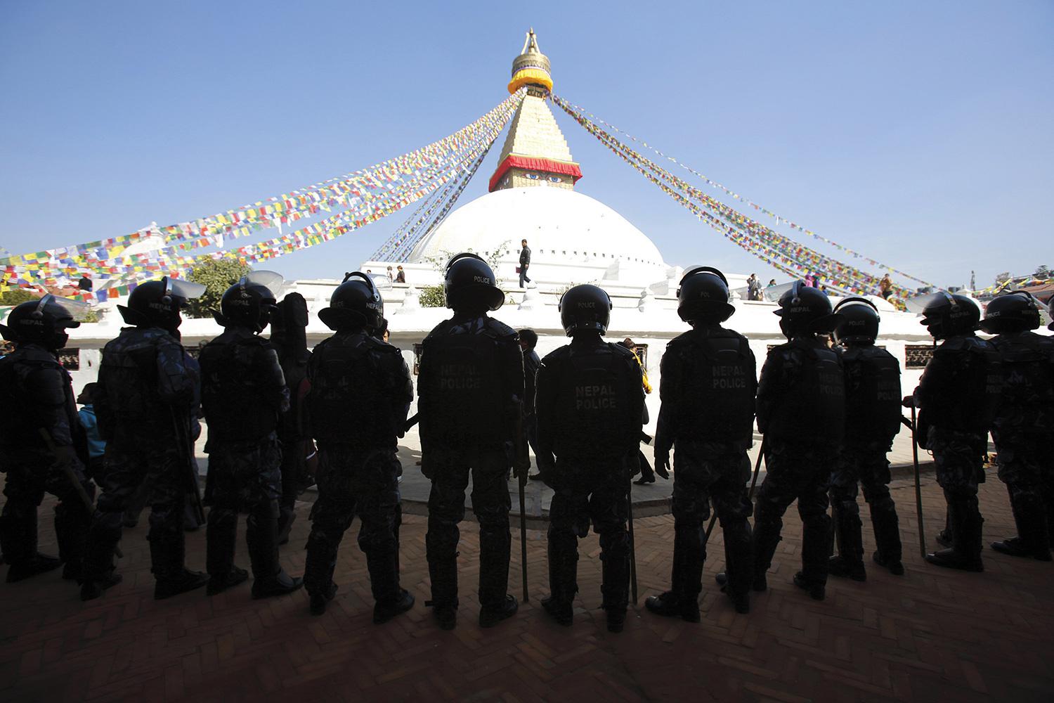Nepalese police stand guard at the premises of the Boudhanath Stupa after a Tibetan monk self-immolated in Kathmandu on February 13, 2013.