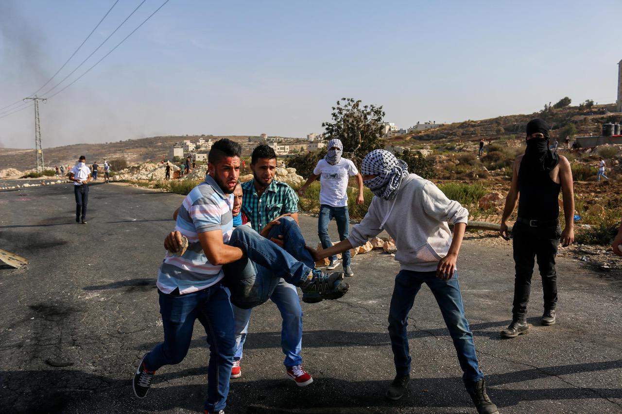 Palestinian youth evacuate an injured Palestinian man shot by Israeli forces at a protest in Ramallah. October 5th, 2015.