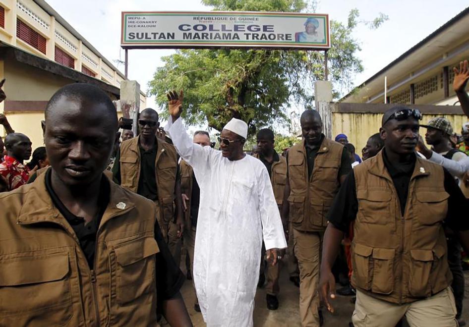Le président en exercice de la Guinée, Alpha Condé, dirigeant du Rassemblement du Peuple de Guinée (RPG), salue la foule en quittant un bureau de vote à Conakry le 11 octobre 2015, lors de l’élection présidentielle dans ce pays.