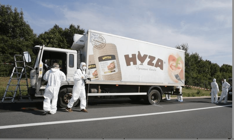 Forensic police officers inspect a parked truck in which up to 50 migrants were found dead, on a motorway near Parndorf, Austria August 27, 2015