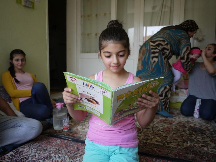 Maya, 9, reads a school textbook in her family home. She enjoys attending her local public school in izmir, on turkey’s west coast, where she is one of four Syrian students in her class.
