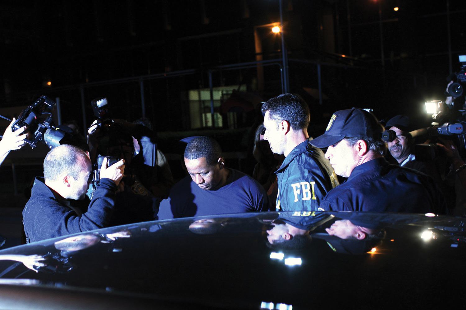 Federal agents and police escort James Cromitie (center) from the FBI’s New York headquarters on May 21, 2009.