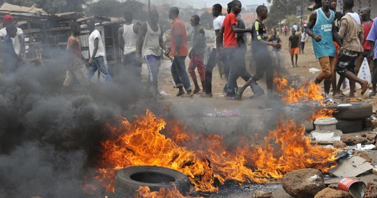 Des pneus brûlent lors d’un affrontement entre policiers et partisans de l’opposition le 13 avril 2015 dans la capitale de la Guinée, Conakry. Manifestants et forces de sécurité se sont opposés suite à un conflit avec le gouvernement concernant le calendr