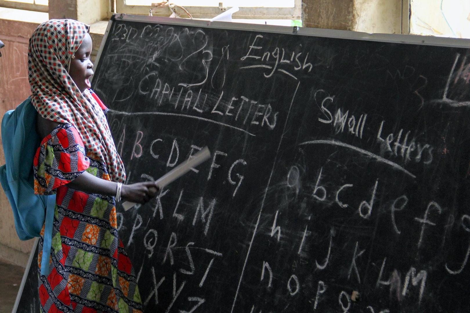 An eager student leads her class in learning the alphabet in September 2015 at a displacement camp housed at a school in Maiduguri, Borno state. © 2015 Bede Sheppard, Human Rights Watch