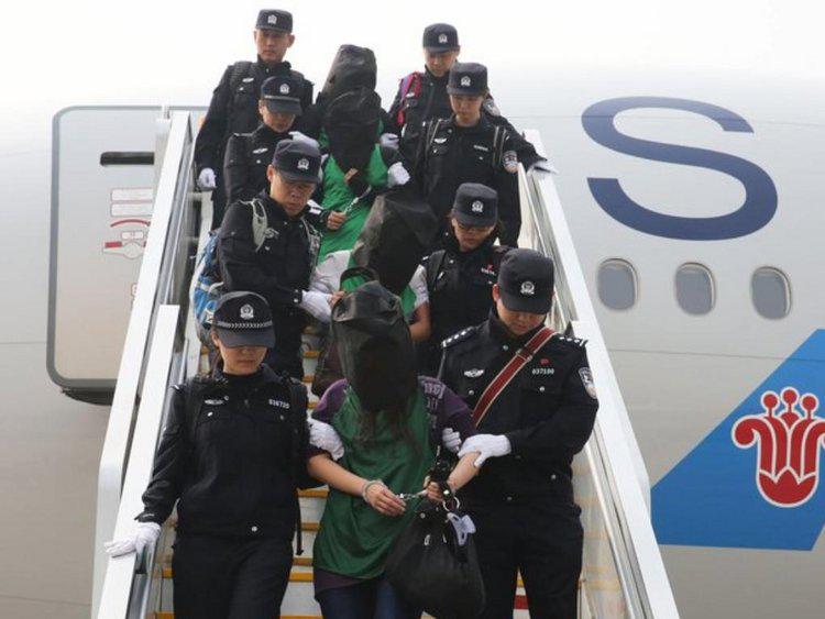 中国警方押送一批遭肯尼亚驱逐人士，在北京首都国际机场步下飞机，2016年4月13日。