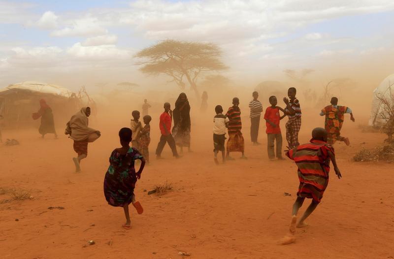 Newly-arrived refugees run away from a cloud of dust at the Dagahaley refugee camp in Dadaab, near Kenya's border with Somalia in Garissa County, Kenya, July 16, 2011.