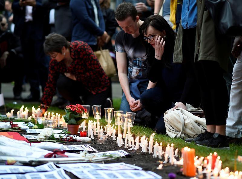 Pessoas acendem velas durante vigília em memória das vítimas do massacre na boate gay em Orlando, na igreja de St. Anne, no bairro Soho de Londres. 13 de junho de 2016.