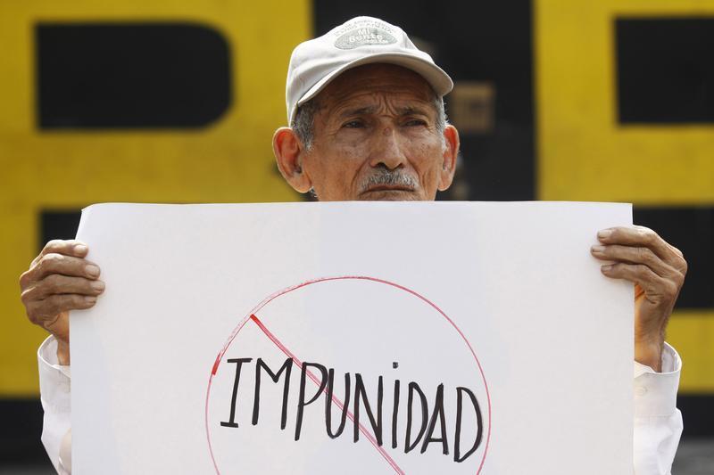 Un hombre lleva un cartel con la palabra “impunidad” durante una protesta en San Salvador, el 24 de agosto de 2011. © 2011 Reuters