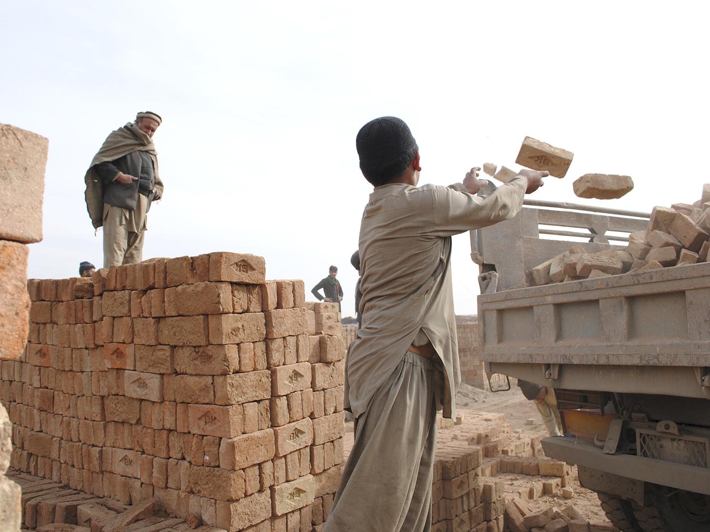Hazrat Hussain, 10, loads bricks onto a truck. Hazrat doesn’t go to school and works alongside his two teenage brothers at a brick kiln outside Kabul.  