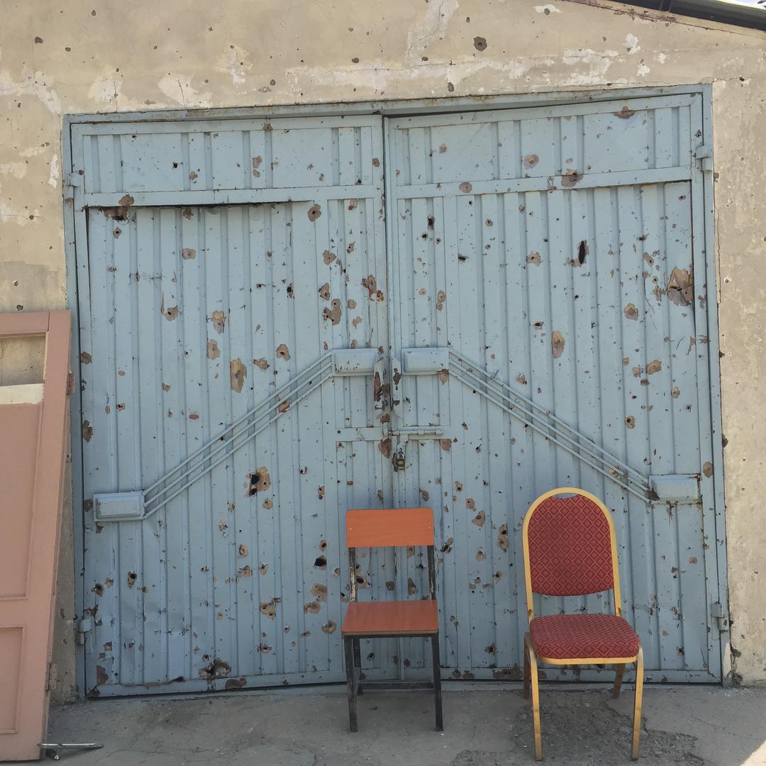 Damage from shrapnel is seen on the walls and locked garage doors at the Vocational High School for the Blind in Kabul, following an attack on August 25, 2016 that left the school closed.