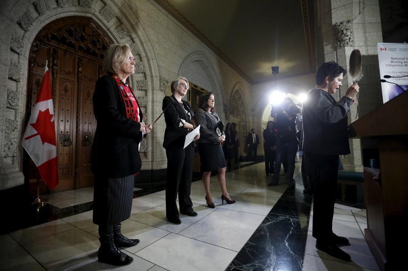 Canada's Indigenous Affairs Minister Carolyn Bennett (L), Status of Women Minister Patricia Hajdu (2nd L) and Justice Minister Jody Wilson-Raybould look on as Algonquin leader Claudette Commanda (R) says a prayer at the start of a news conference