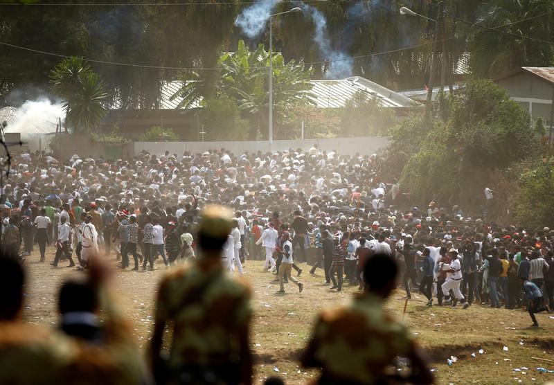 Protestors run from tear gas launched by security personnel during the Irecha, the thanks giving festival of the Oromo people in Bishoftu town of Oromia region, Ethiopia, October 2, 2016.