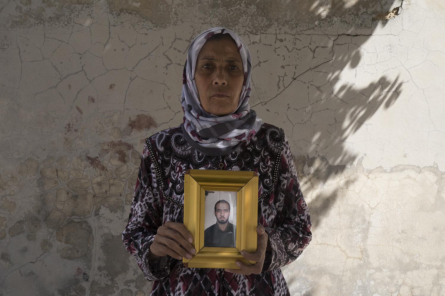 Zakia Hassan, une habitante de la ville de Manbij dans le nord de la Syrie, tient une photo de son fils, Ibrahim Hammoud, tué le 12 août 2016 à l’âge de 35 ans par un engin explosif qui avait été dissimulé dans un matelas par les combattants de l’Etat isl