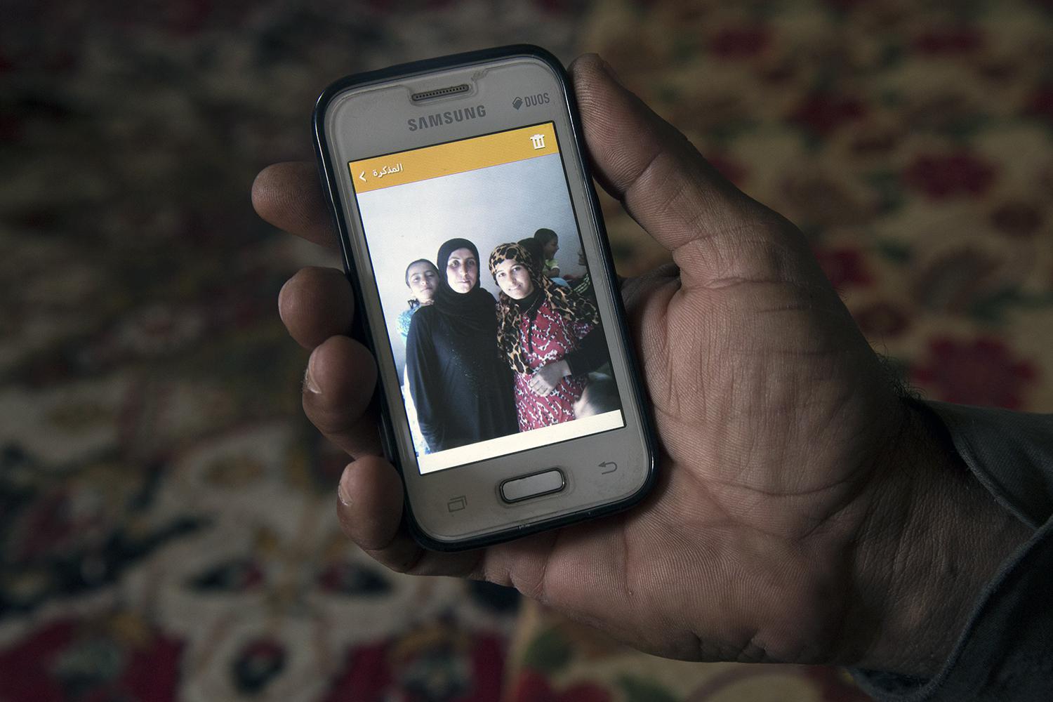 Khaled Abdi shows a photograph of his daughter, 18, who was killed when a device exploded as they were returning to their house on August 18 after fighting ended. 