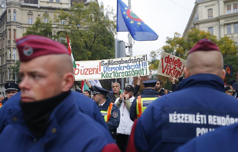 Hungarian police stand guard in front of anti-government protesters near to a ceremony marking the 60th anniversary of 1956 anti-Communist uprising in Budapest, Hungary, October 23, 2016.