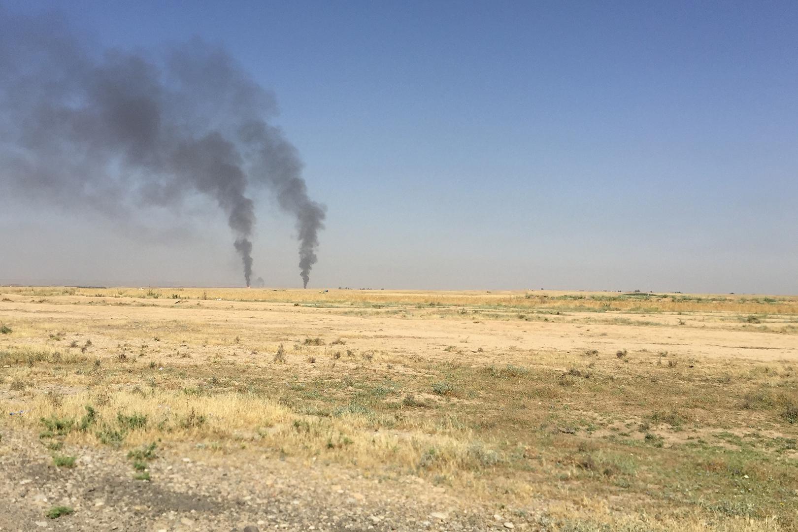 آبار نفط تحترق، ظاهرة للعيان من قرية قره تبه، في 20 مايو/أيار 2016.