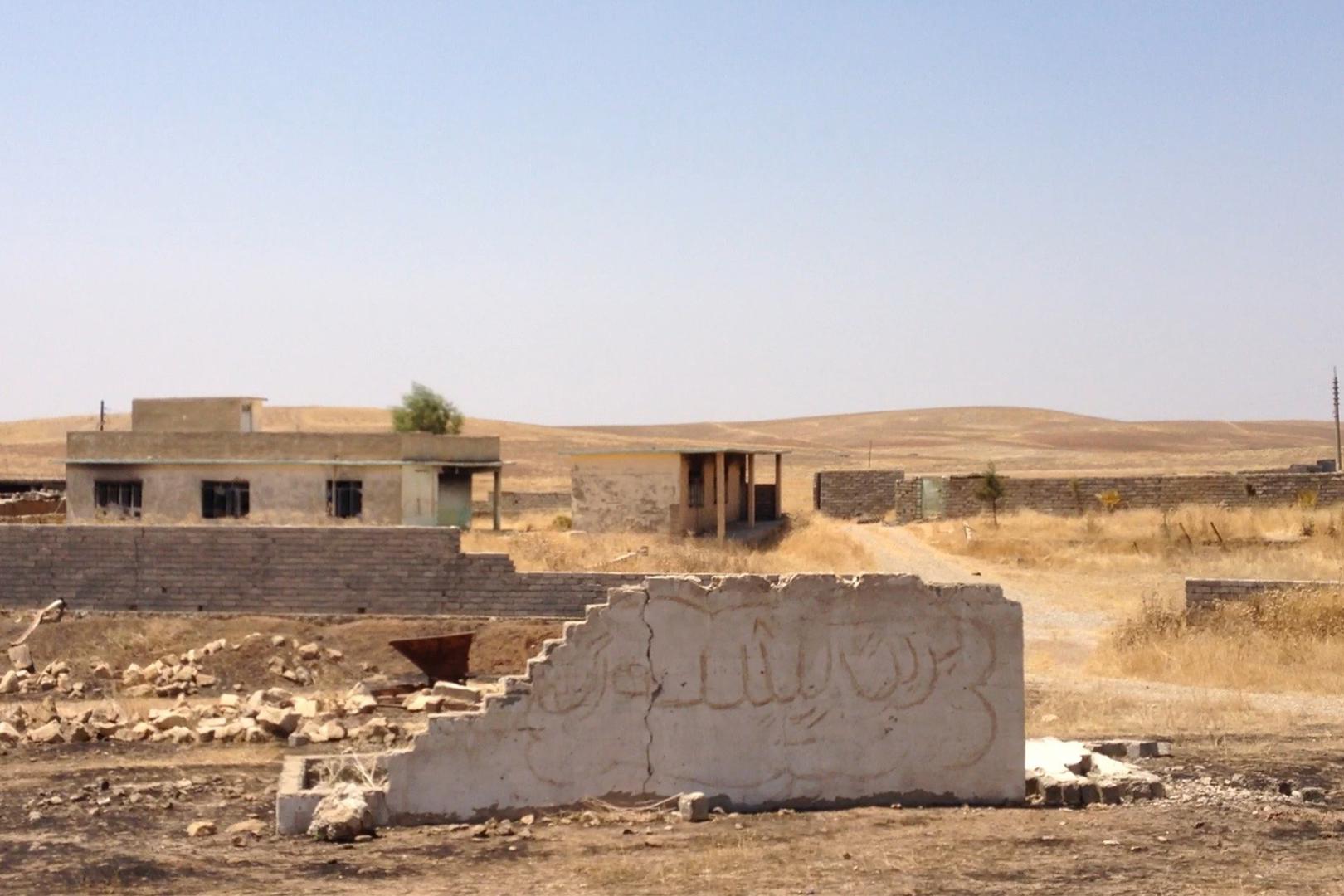 منازل محترقة ومهدّمة في شيخان، وعليها كتابات "عاشت البشمركة". © 2015 هيومن رايتس ووتش