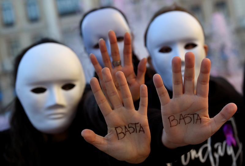 Gender studies students wearing masks pose with the word "Enough" written on their hands during a performance to commemorate victims of gender violence, during the U.N. International Day for the Elimination of Violence against Women, in Oviedo, Spain Nove