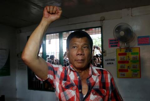 Rodrigo Duterte raises a clenched fist before casting his vote for national elections in Davao city, Philippines on May 9, 2016.